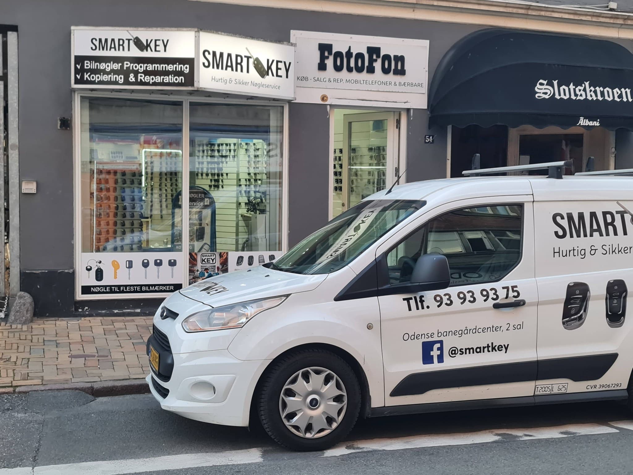 SmartKey service-bil parkeret foran butikken på Odense Banegård Center — Bilnøgler SmartKey hjælper med bilnøgler, programmering, kopiering og reparation.